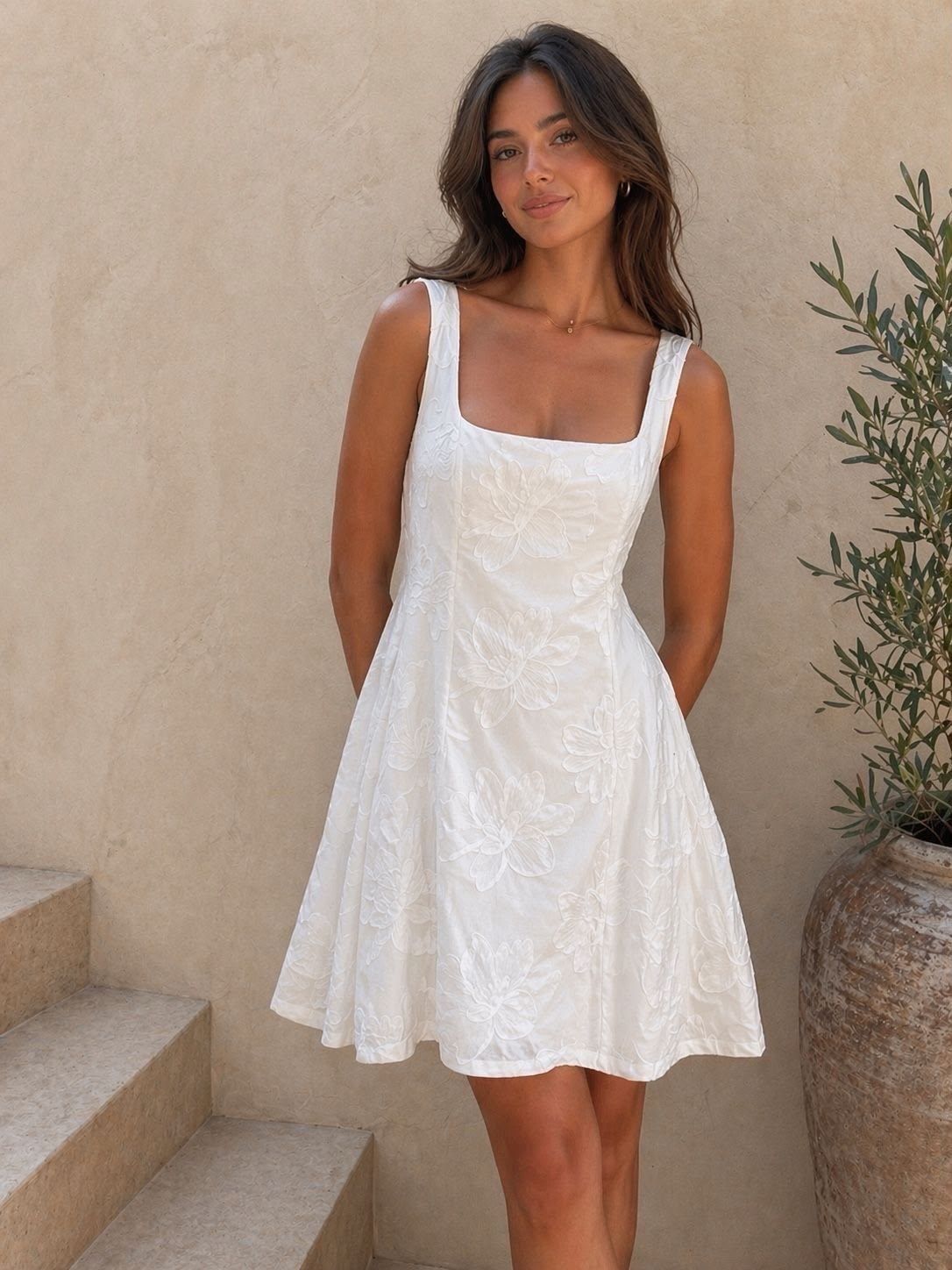 Model in weißem Kleid mit Blumenstruktur